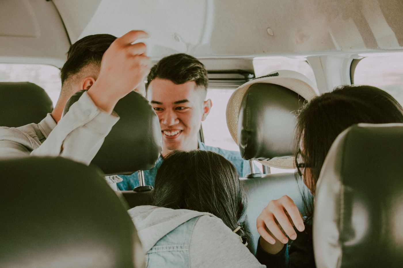 Friends turning around in their seats in a van, laughing